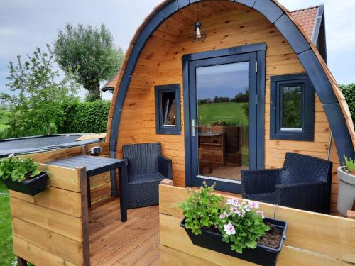 a circular house with a patio and a table and chairs at Vakantiehuisjes Marsherne in Poppingawier