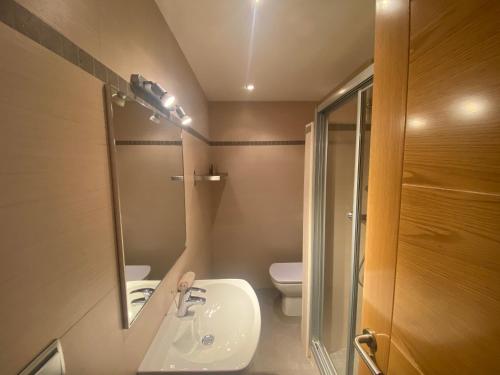 łazienka z umywalką, toaletą i lustrem w obiekcie Albamar frontline Beach apartment 3 bedrooms w mieście Fuengirola