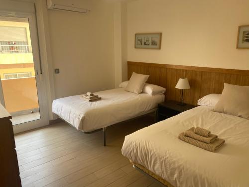 pokój hotelowy z dwoma łóżkami i oknem w obiekcie Albamar frontline Beach apartment 3 bedrooms w mieście Fuengirola