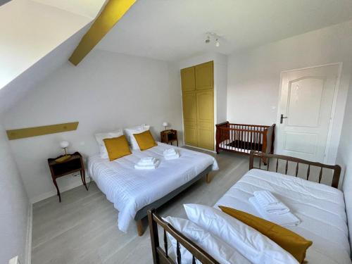 um quarto com 2 camas e almofadas amarelas em Gold - Ferme Delaunay em Saint-Côme-du-Mont