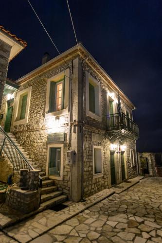 an old stone house with lights on it at night at Gerofotis Traditional Guesthouse est 1892 - Close to Aigio, Akoli, Selianitika in Lákka