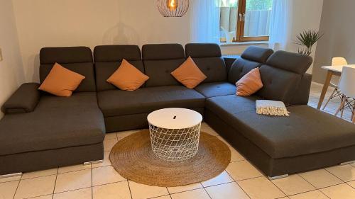 a living room with a blue couch and orange pillows at Apartment near Europa-Park & Black Forest in Kappel-Grafenhausen