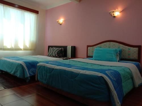 two beds in a room with pink walls at Glory Beach Resort PriVate PentHouse in Port Dickson