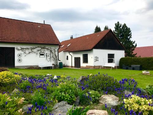 a white house with flowers in the yard at Venkovská usedlost Horšice in Horšice
