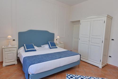 a bedroom with a blue bed with two blue pillows at Hotel Garden Riviera in Santa Maria di Castellabate