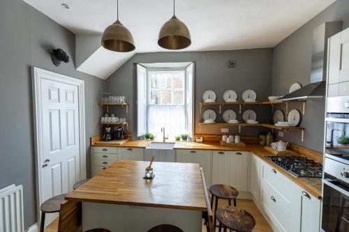 a kitchen with a wooden table and some chairs at DUNDAS COTTAGE - Beautiful Spacious 3 Bed Cottage in Richmond, North Yorkshire in Richmond