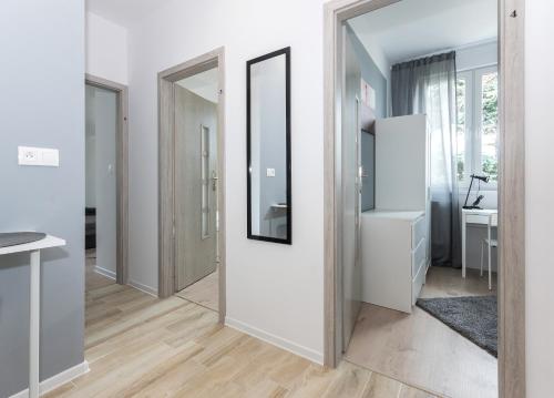 a hallway with white walls and a mirror at Pokoje Gdańsk Oliwa - Mściwoja II 50, do morza 1,9km, 750m SKM Oliwa, 1,1km Park Oliwski in Gdańsk