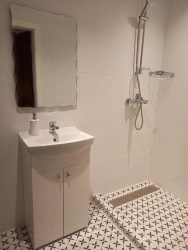 a white bathroom with a sink and a mirror at Rožu iela in Sigulda