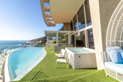 a house with a swimming pool and the ocean at The Marvel Beach House in Cape Town