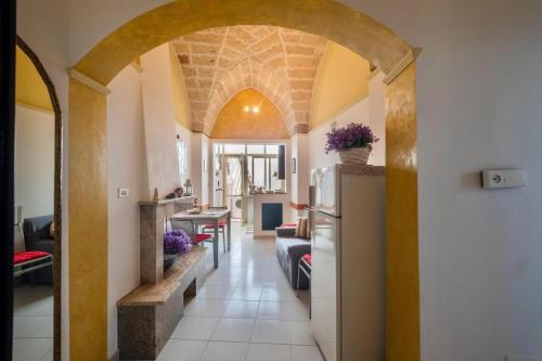 a hallway with an archway in a house with a refrigerator at Casa Amata Salentina in Squinzano