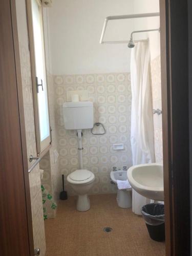 a bathroom with a toilet and a sink at Alice Hotel in Cervia