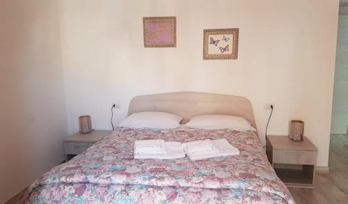 a bedroom with a bed with two tables and two towels at Casa Iacovelli in Casalvecchio di Puglia