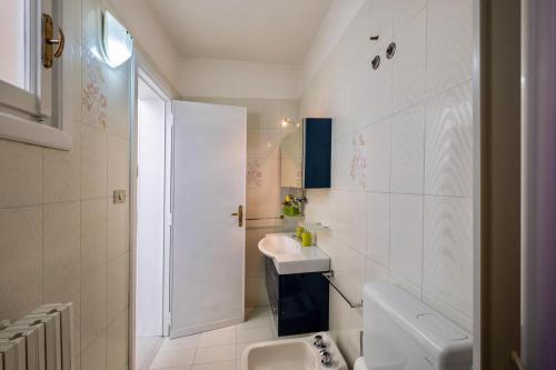 uma casa de banho branca com um lavatório e um WC em Casa Amata Salentina em Squinzano