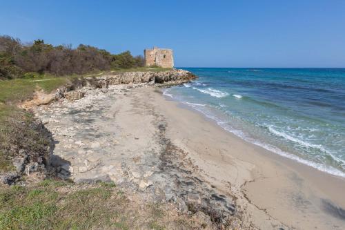 a beach with a castle in the middle of the ocean at Residence Solaris in San Foca
