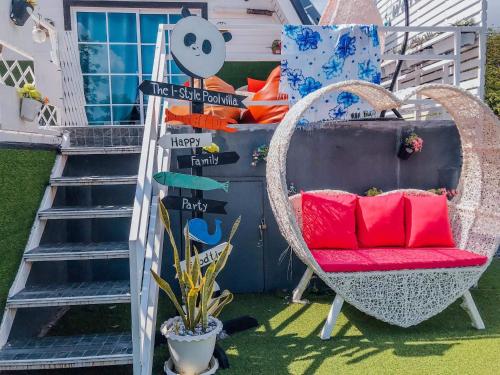 a wicker chair with a red cushion sitting in a yard at The I-style pool villa in Ban Tao Than