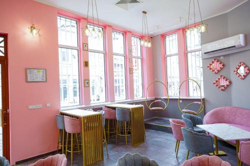 a restaurant with pink walls and bar stools at Hotel Kiev in Veliko Tŭrnovo