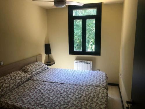 een slaapkamer met een bed en een raam bij Apartamento MIRABOSQUE - plaza garaje incluida in Arenas de San Pedro