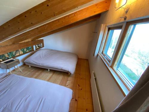 um pequeno quarto com uma cama e uma janela em FamC em Nakafurano