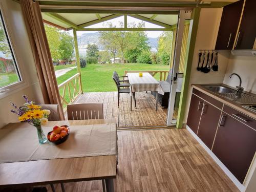 a kitchen and dining room with a view of a yard at Camping Neubauer - Mobilheime in Millstatt