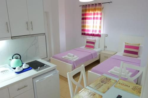 a small room with two beds and a table and chairs at Hotel Mira Mare in Ksamil