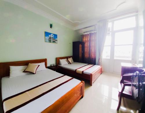 um quarto com 2 camas e uma janela em Hoang Long Hotel Bai Chay em Ha Long