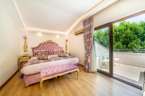 a bedroom with a pink bed and a balcony at Sundia By Liberty Oludeniz in Oludeniz