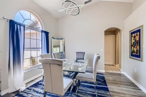 ein Esszimmer mit einem Tisch, Stühlen und einem Fenster in der Unterkunft NEW Modern Relaxing 4 Bedroom Pool Villa Near Disney's Parks in Davenport