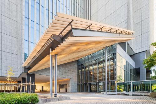 a building with a wooden canopy in front of it at The Capitol Hotel Tokyu in Tokyo
