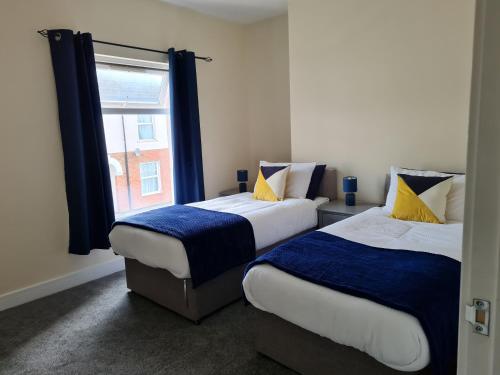 two beds in a room with a window at The Albemarle in Hull