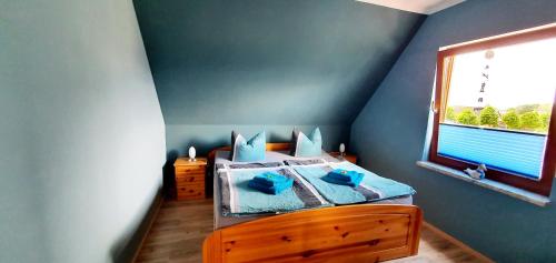 una camera da letto con un letto con cuscini blu e una finestra di Caroline & Maurice a Ostseebad Koserow