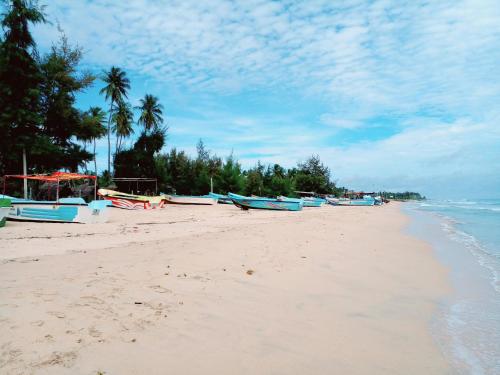 a beach with boats on the sand and the water at U new guest house in Nilaveli