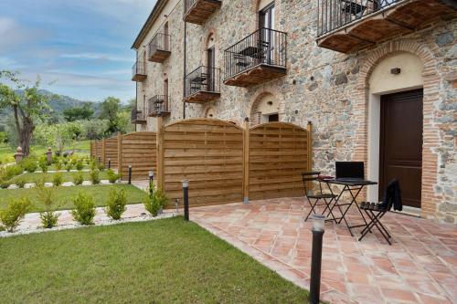 a house with a wooden fence and a patio at Tenuta Ciminata Greco in Rossano