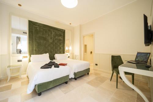 a bedroom with a bed and a desk with a laptop at Tenuta Ciminata Greco in Rossano
