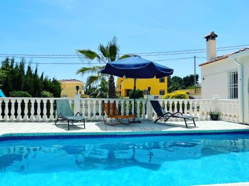 uma piscina com duas cadeiras e um guarda-sol em Villa la Vida em L'Alfàs del Pi