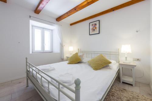 a bedroom with a white bed and a window at Villa Lizza in Cavtat