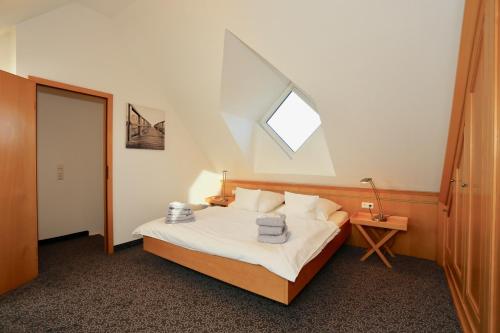Schlafzimmer mit einem Bett und einem Dachfenster in der Unterkunft Wohnung Peper in Juist