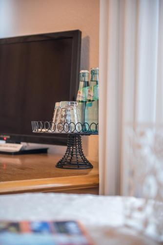 a table with a tv and some bottles and glasses at Bilz-Pension in Radebeul