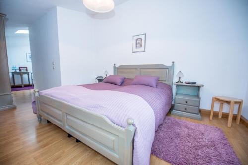 a bedroom with a bed with purple sheets and a purple rug at Bilz-Pension in Radebeul