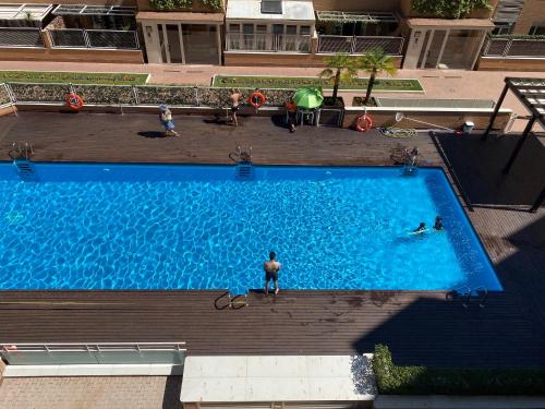 einen Blick über einen Pool mit Menschen darin in der Unterkunft Alcobendas Cómodo y luminoso Un dormitorio in Alcobendas