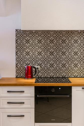 a red kettle on a counter with a patterned wall at Villa Lizza in Cavtat