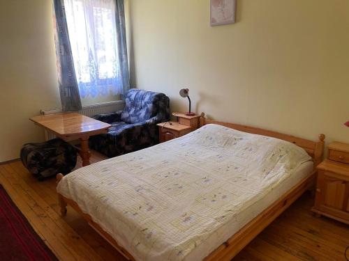 a bedroom with a bed and a chair and a table at Вила Мечта in Tryavna