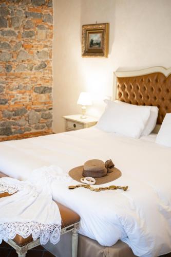 a hat sitting on a bed in a bedroom at Tenuta Ciminata Greco in Rossano