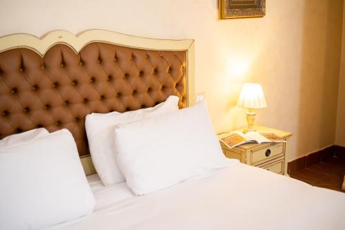 a hotel room with a bed and a night stand with a phone at Tenuta Ciminata Greco in Rossano
