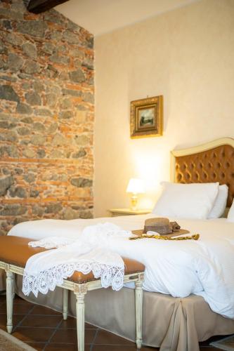 a bedroom with two beds and a stone wall at Tenuta Ciminata Greco in Rossano