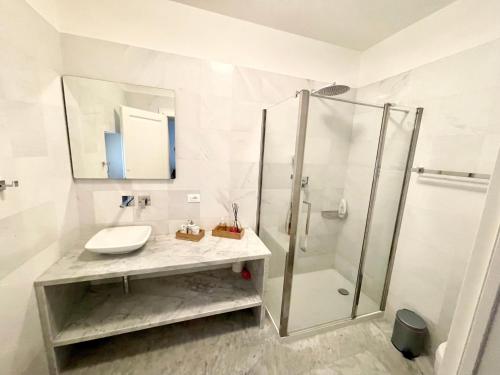 a white bathroom with a sink and a shower at Villa Podere Del Grasso in Castel del Piano