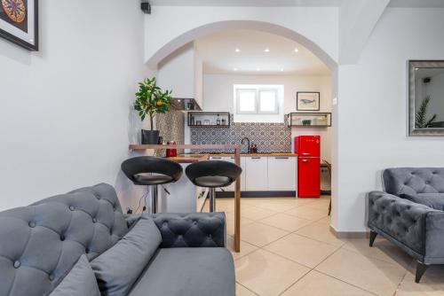 een woonkamer met een bank en stoelen en een keuken bij Villa Lizza in Cavtat