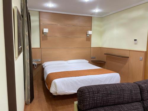 a hotel room with a bed and a couch at Hotel Malena in Caravaca de la Cruz