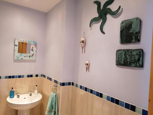 a bathroom with a sink and skulls on the wall at Carlingford Mountain and Sea Views in Carlingford