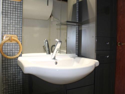 un lavabo blanc dans une salle de bain avec un miroir dans l'établissement Appart 6 pers, 50m plage, balcon, parking, animaux admis - FR-1-229C-338, à Port-la-Nouvelle