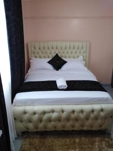 a bedroom with a large bed with a black and white blanket at Executive Studio in Nakuru